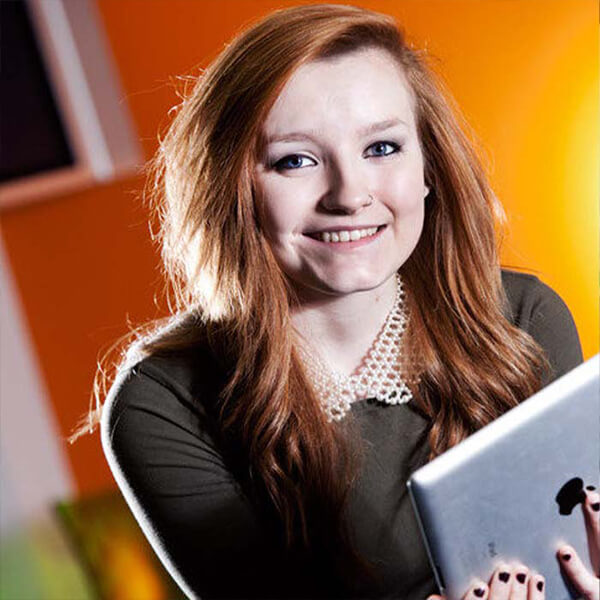 Young woman holding a smart tablet and smiling.